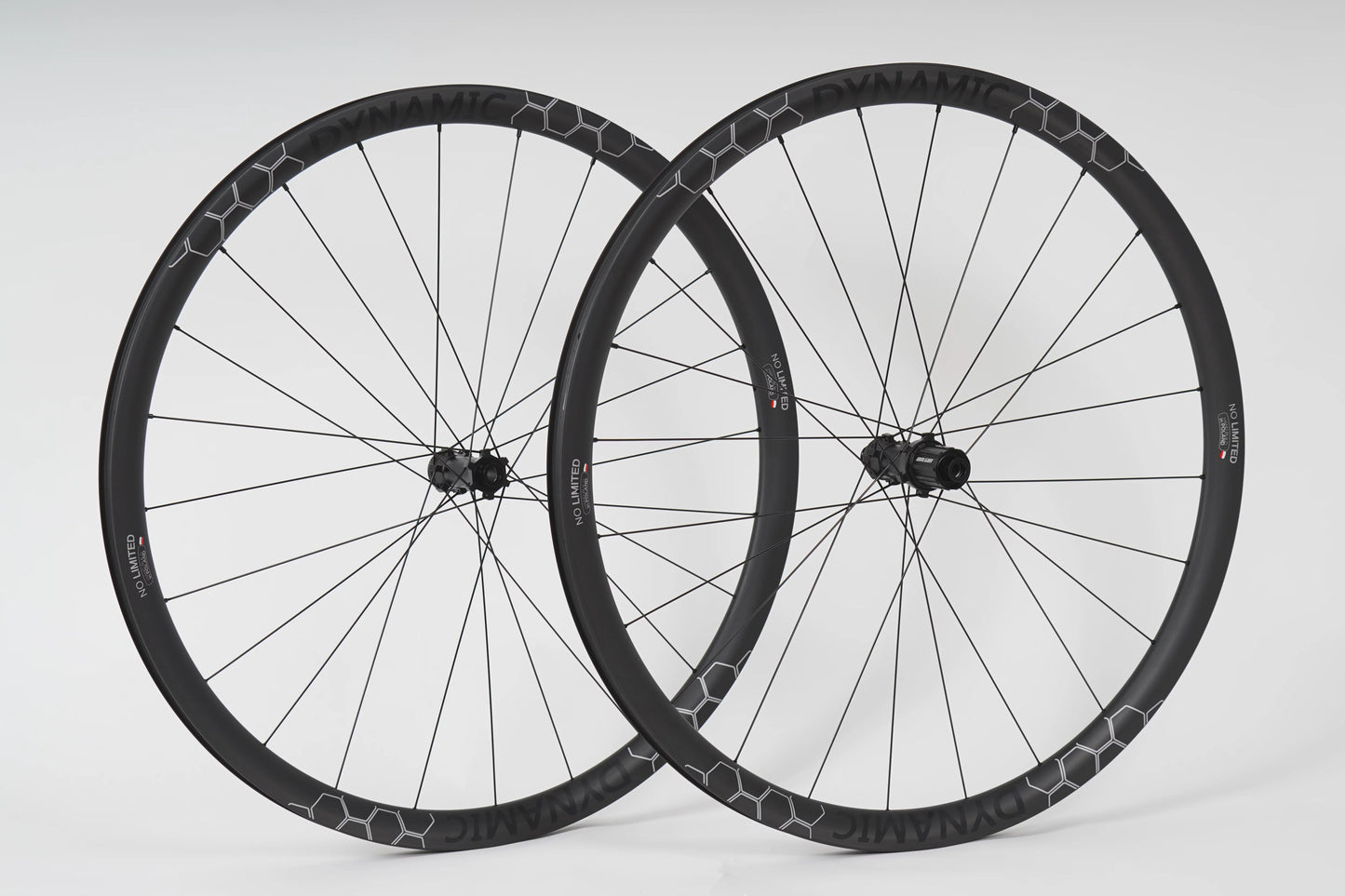 Two bicycle wheels with black rims and white spokes on a light gray background