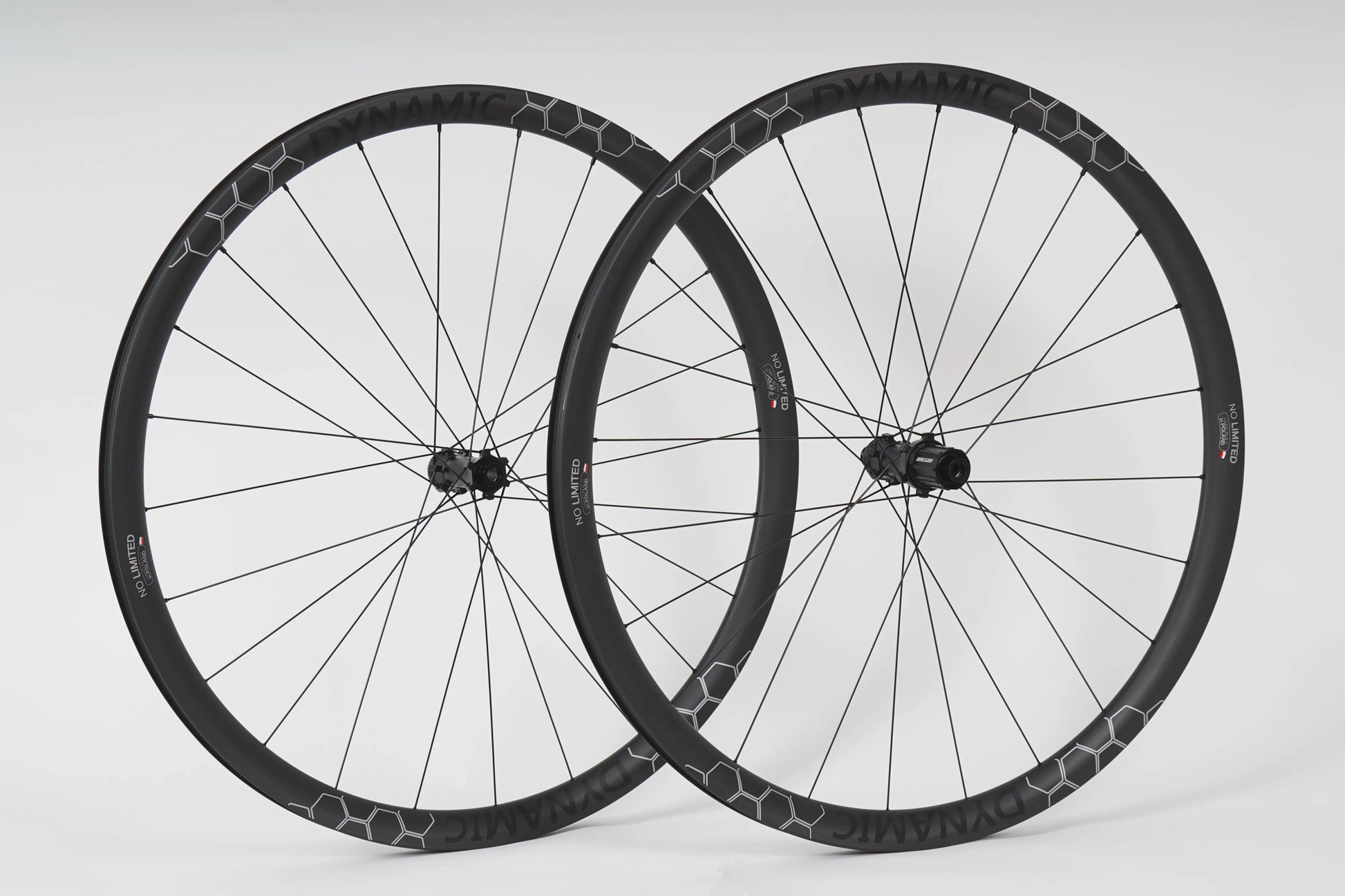 Two bicycle wheels with black rims and white spokes on a light gray background
