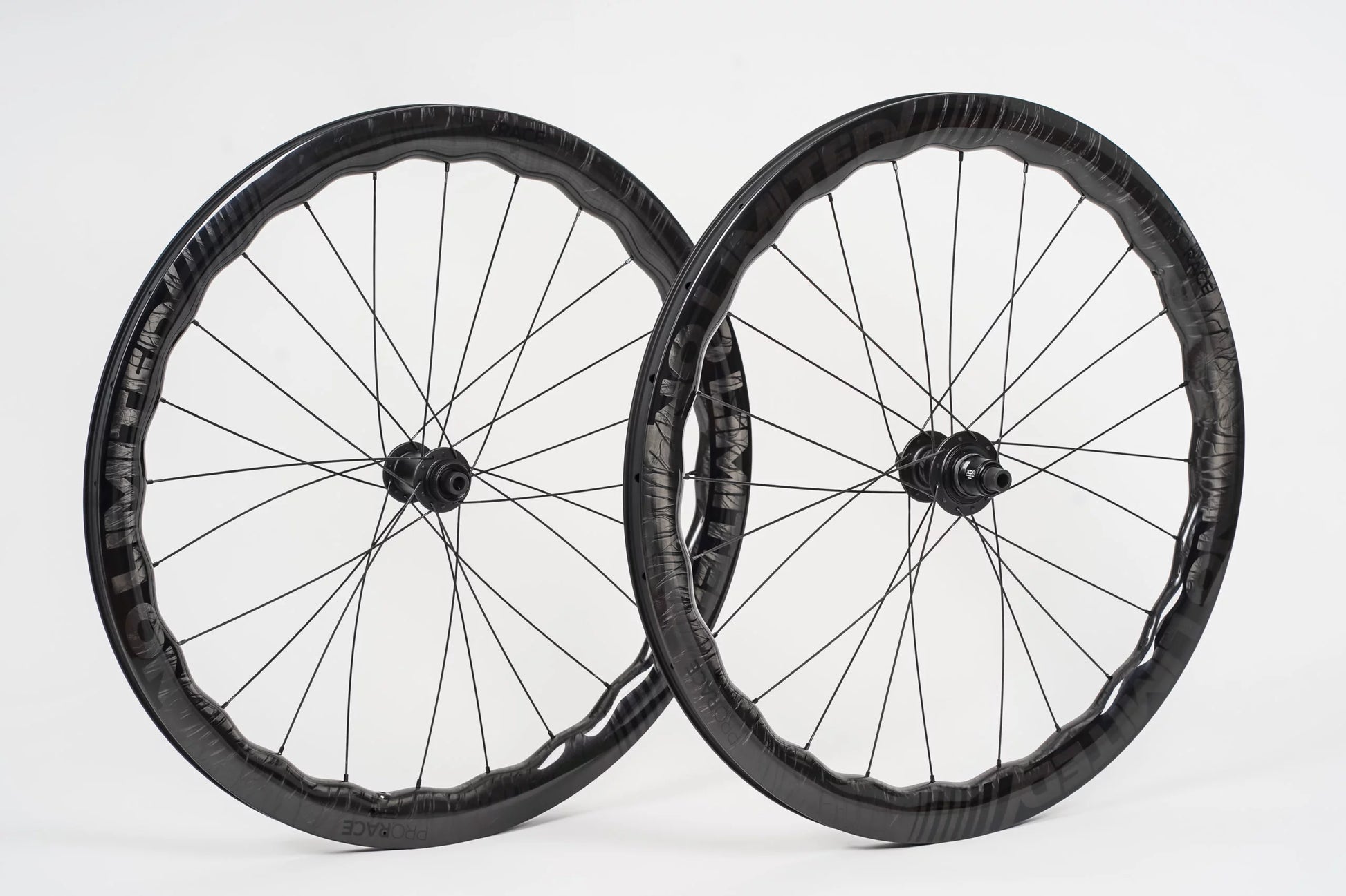Two bicycle wheels with black rims and spokes on a white background