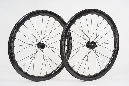 Two bicycle wheels with black rims and spokes on a white background