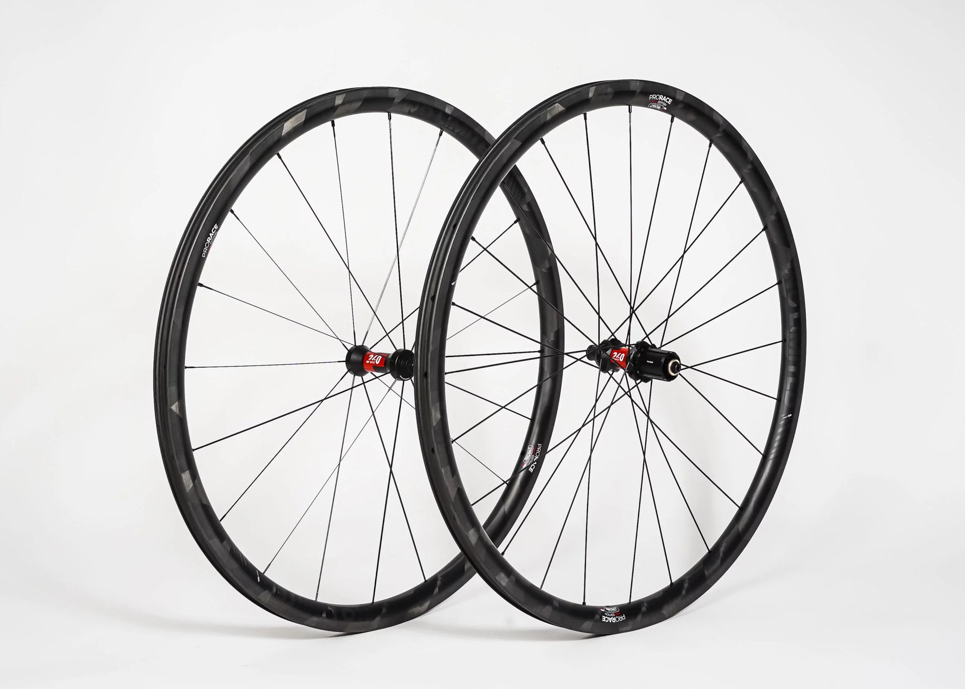 Two bicycle wheels with black rims and red hubs on a white background