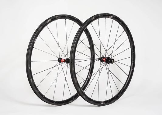 Two bicycle wheels with black rims and red hubs on a white background