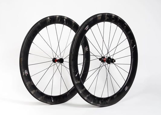 Two black bicycle wheels on a white background