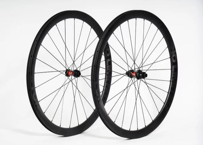 Two bicycle wheels with black rims and red hubs on a white background