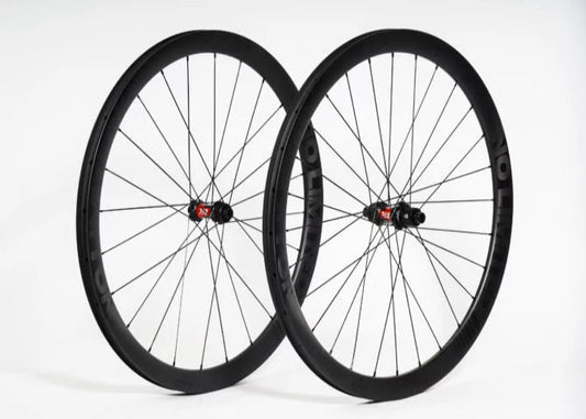 Two bicycle wheels with black rims and red hubs on a white background